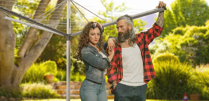 Zwei Menschen stehen nebeneinander unter einer Wäschespinne im Garten